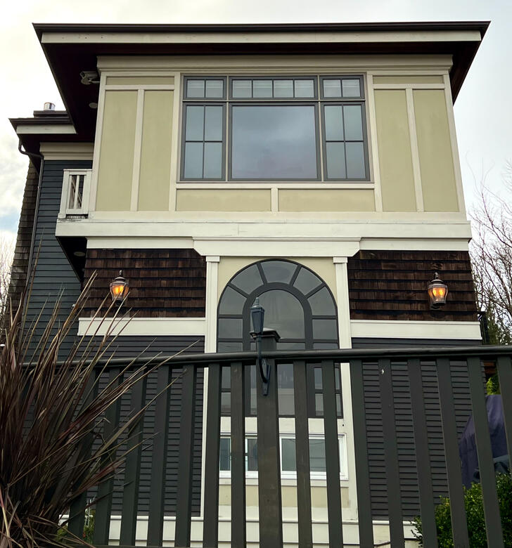 Renovated craftsman home exterior with painted trim and an arched entry in Seattle